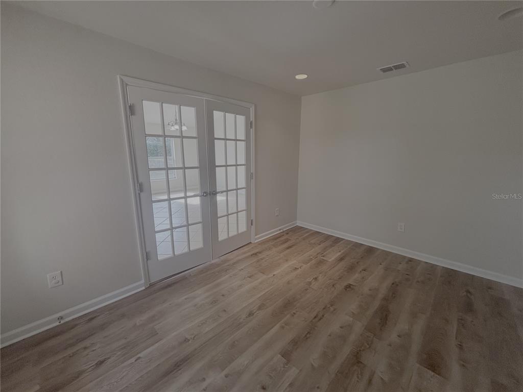 4194 Southwest 47th Court Ocala, FL 34474 - Photo 20 of 29 an empty room with wooden floor and windows