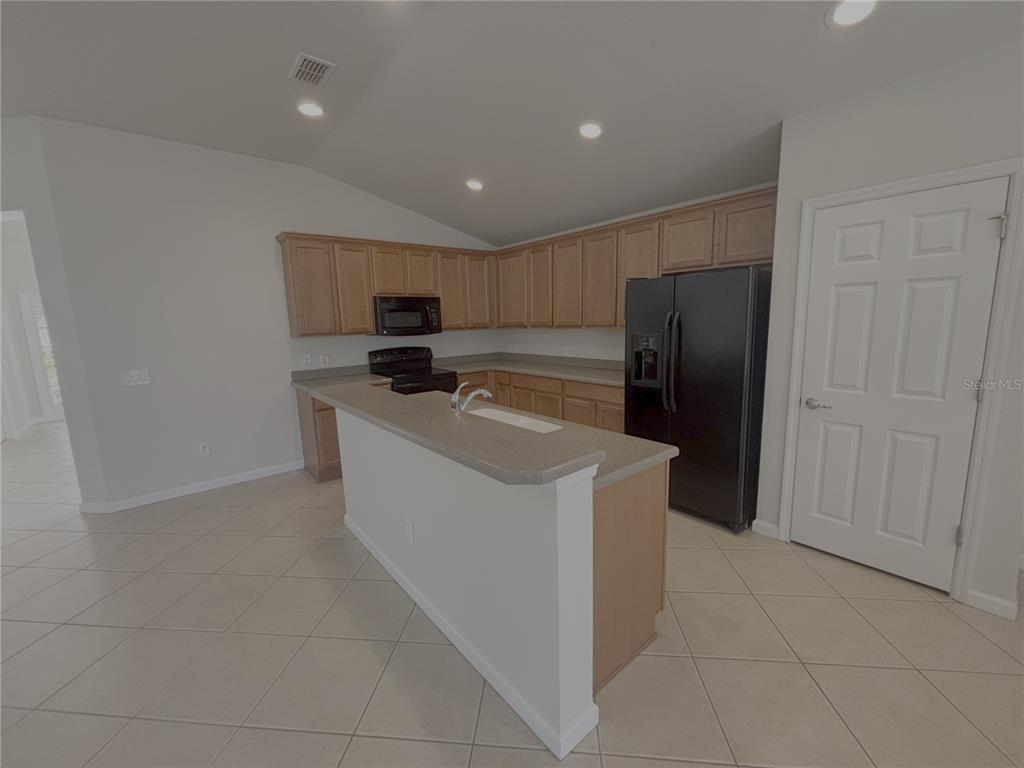 4194 Southwest 47th Court Ocala, FL 34474 - Photo 8 of 29 a kitchen with stainless steel appliances granite countertop a refrigerator a stove a sink and a refrigerator with white cabinets