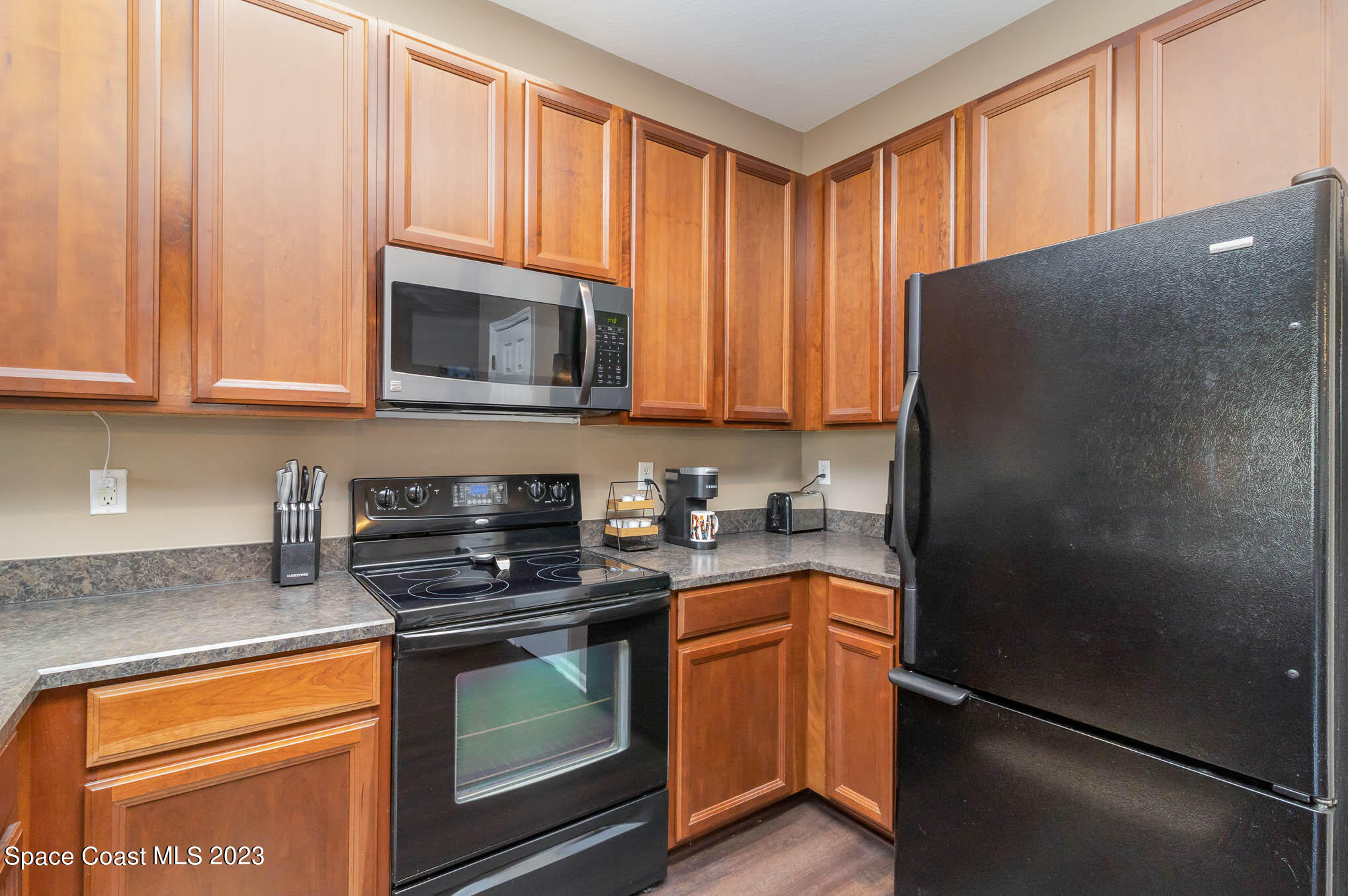 2805 Reston Street, Unit 103 Melbourne, FL 32935 - Photo 12 of 36 a kitchen with granite countertop a refrigerator stove and microwave