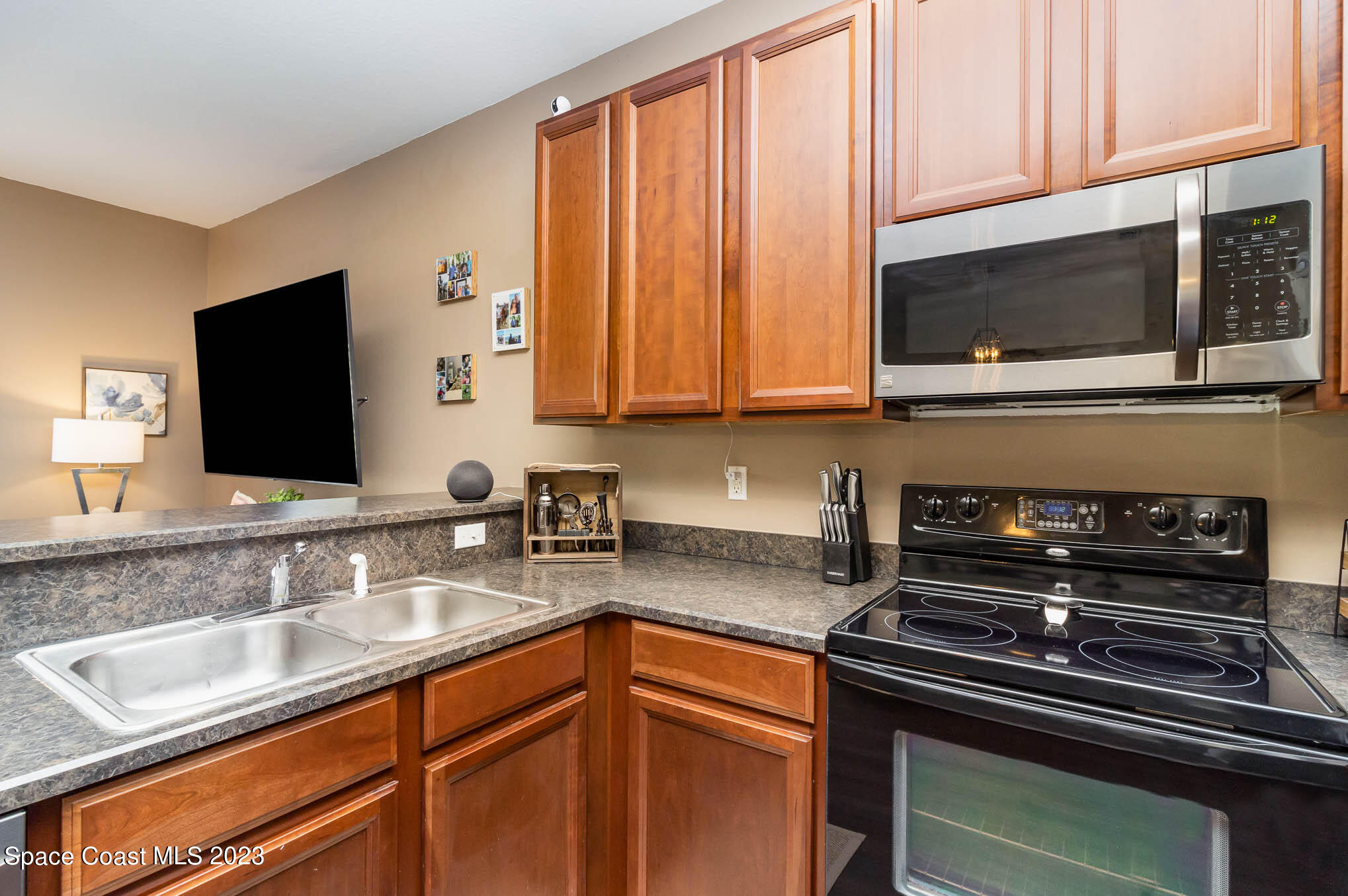 2805 Reston Street, Unit 103 Melbourne, FL 32935 - Photo 13 of 36 a kitchen with stainless steel appliances granite countertop a sink stove and microwave