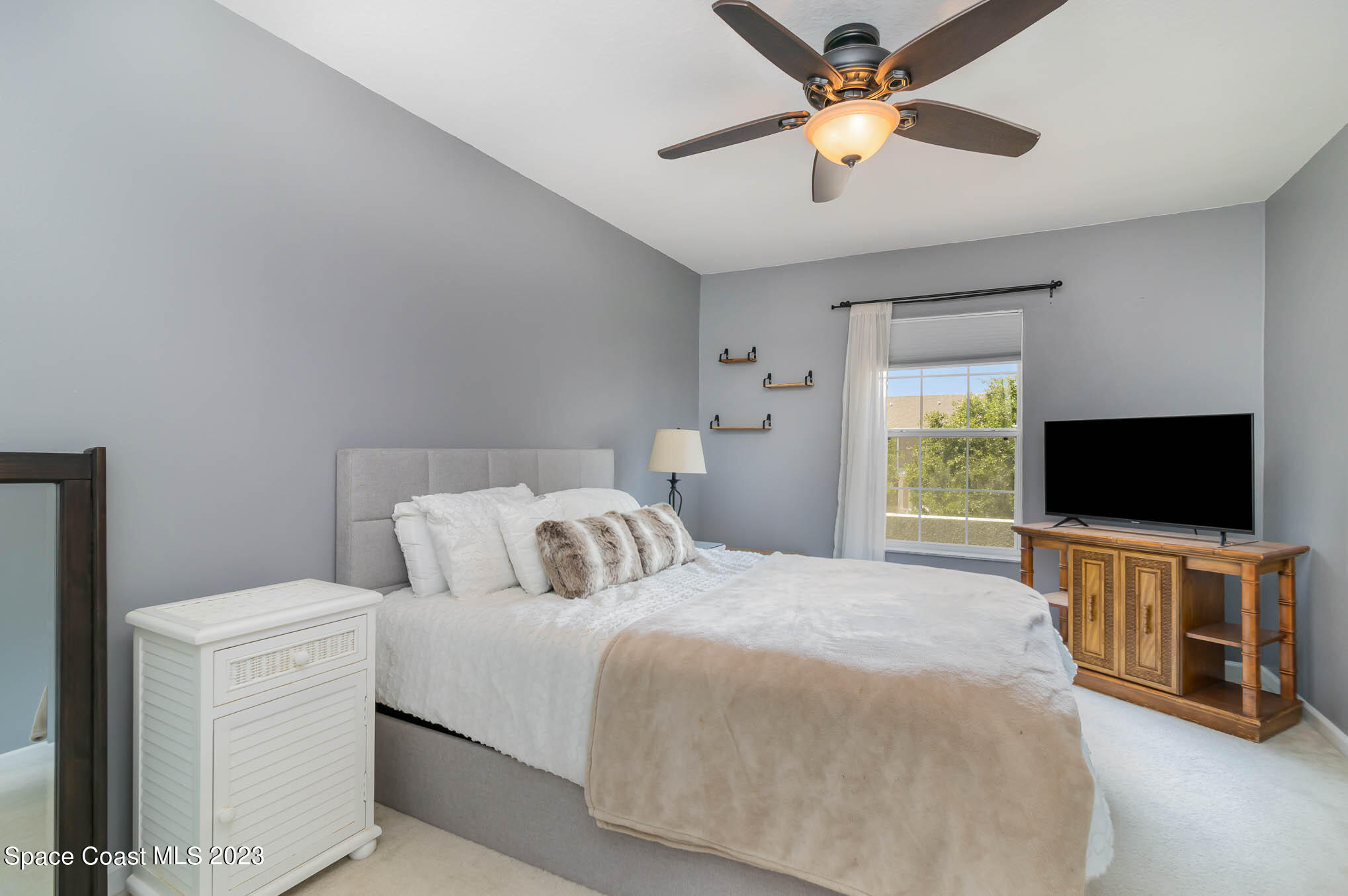 2805 Reston Street, Unit 103 Melbourne, FL 32935 - Photo 16 of 36 a bedroom with a bed and a flat tv screen on dresser