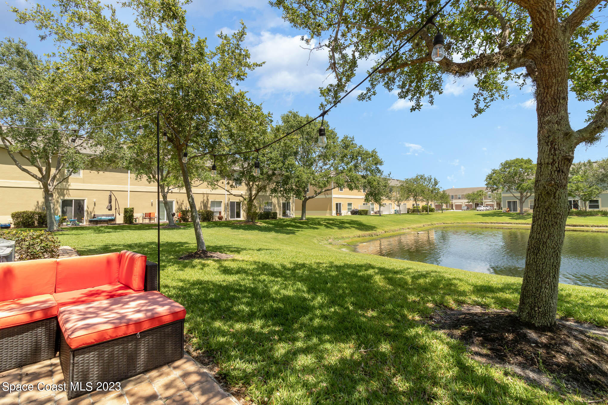 2805 Reston Street, Unit 103 Melbourne, FL 32935 - Photo 27 of 36 a view of a lake with couches and table and chairs next to trees