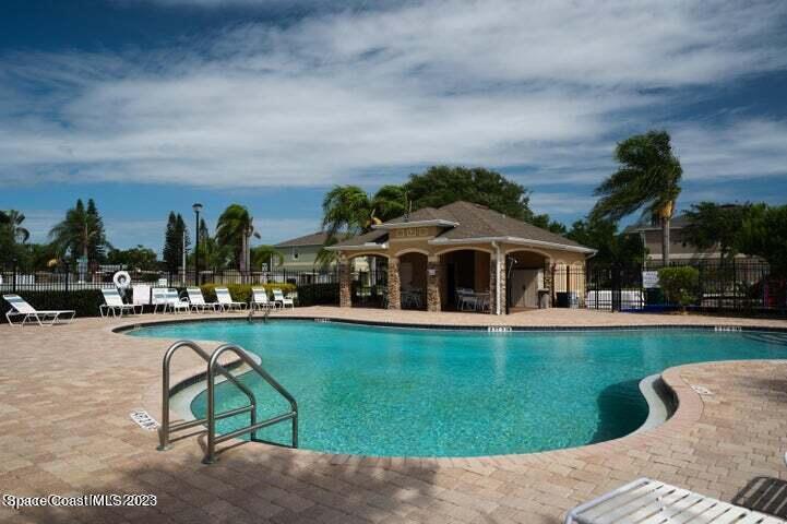 2805 Reston Street, Unit 103 Melbourne, FL 32935 - Photo 29 of 36 a view of swimming pool with outdoor seating and trees in the background