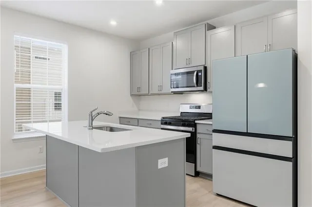 a kitchen with kitchen island a counter top space cabinets and stainless steel appliances
