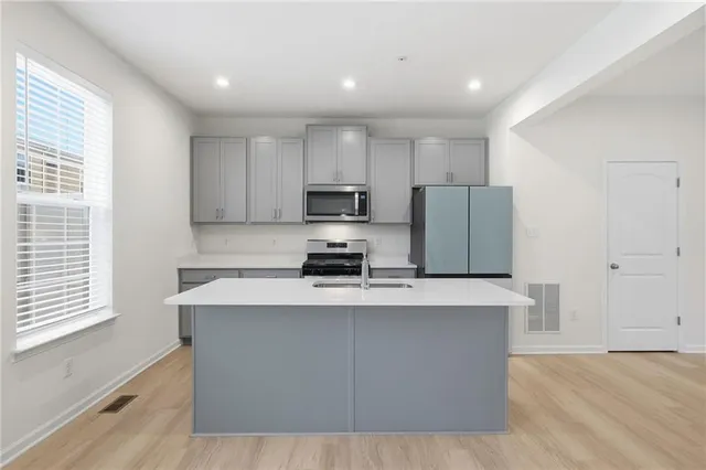 a kitchen with stainless steel appliances a refrigerator a stove a microwave and cabinets