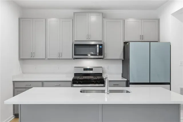 a kitchen with appliances a sink and cabinets