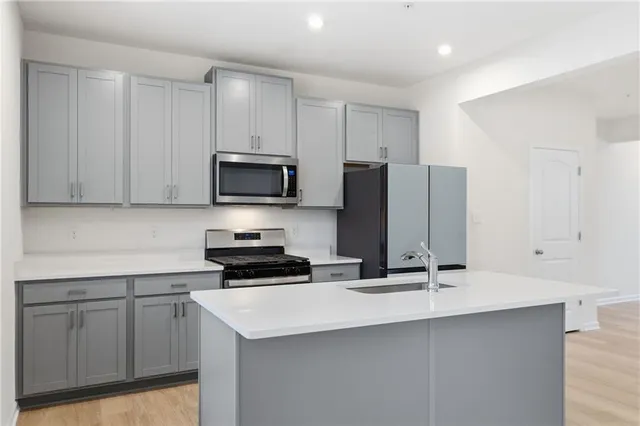 a kitchen with granite countertop a sink stove and microwave