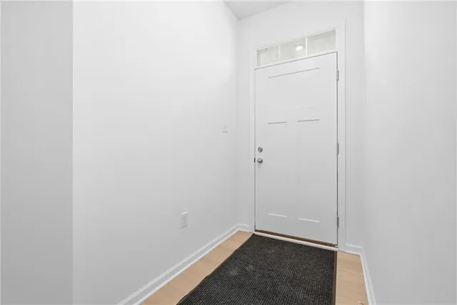 a view of staircase with white walls and white door