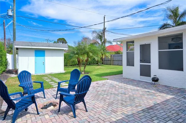 a view of a patio with a table chairs and a yard