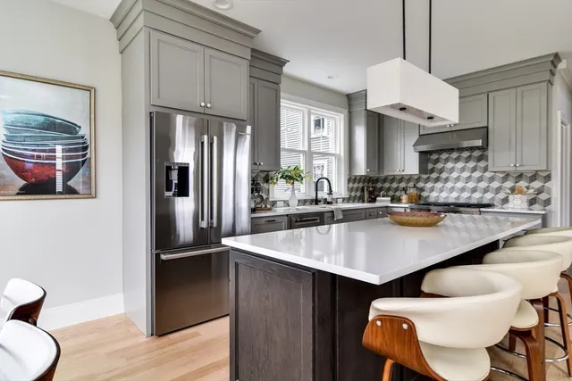 a kitchen with stainless steel appliances granite countertop a sink a stove and a refrigerator