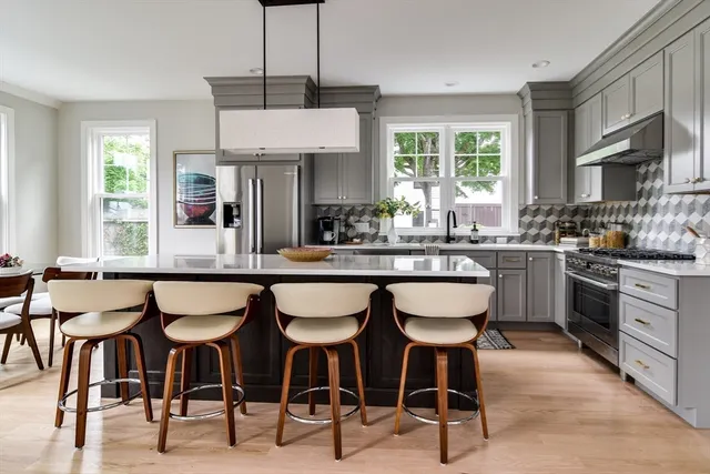 a kitchen with a dining table chairs sink and white cabinets