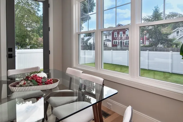 a dining room with furniture and large windows