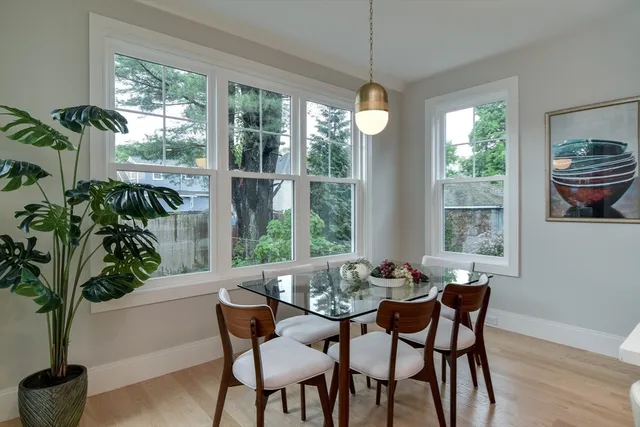 a dining room with furniture potted plants and wooden floor