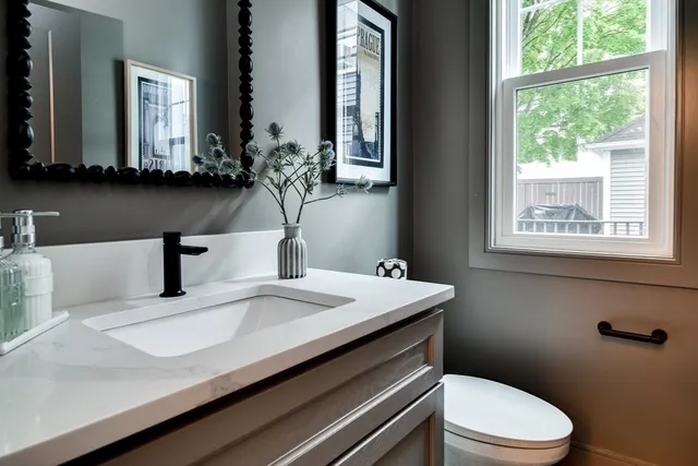 a bathroom with a sink a toilet and mirror