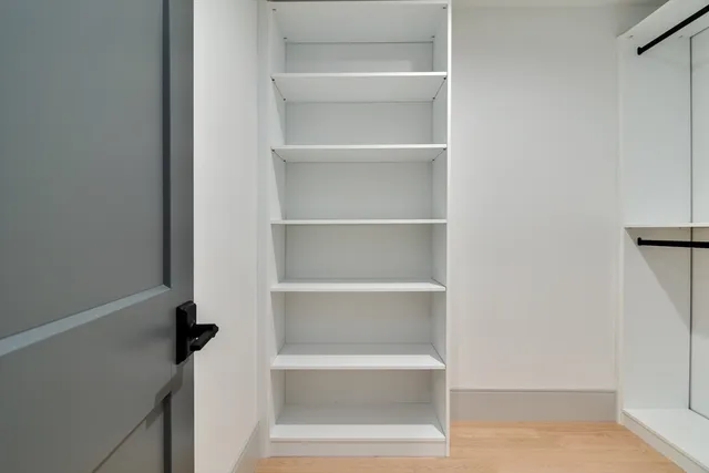 a view of walk in closet with empty racks