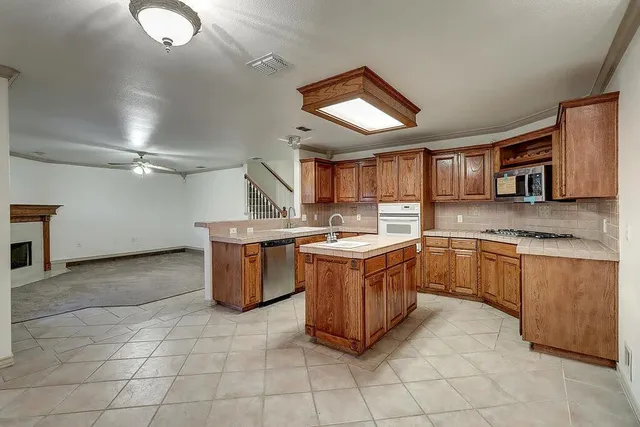 a kitchen with a stove top oven cabinets a sink and a counter top space