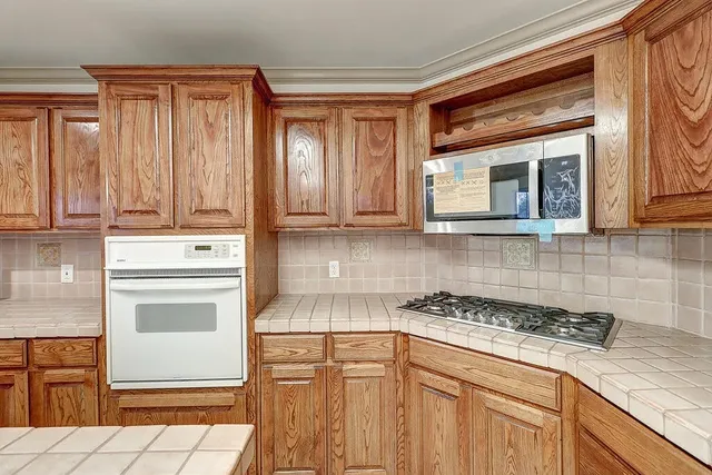 a kitchen with stainless steel appliances granite countertop a stove a microwave and cabinets