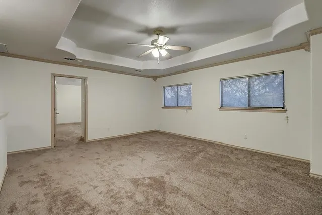 an empty room with a ceiling fan and a window