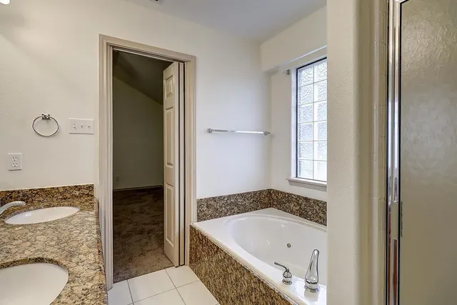 a bathroom with a tub sink and mirror