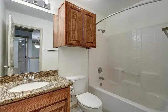a bathroom with a granite countertop sink toilet and shower