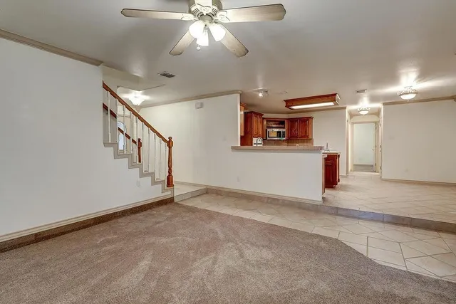 a view of a livingroom with wooden floor and ceiling fan