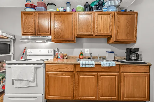 a kitchen with stainless steel appliances granite countertop a sink dishwasher stove and cabinets