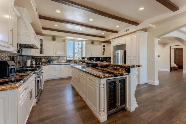a kitchen with stainless steel appliances granite countertop a stove a sink dishwasher and cabinets with wooden floor