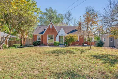 a front view of a house with a yard and trees