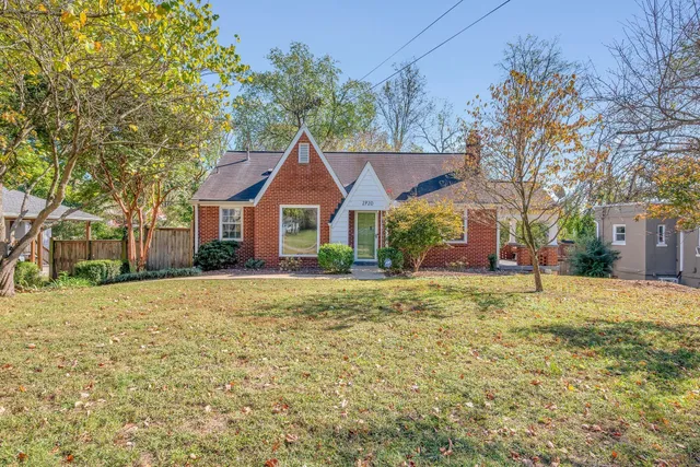 a front view of a house with a yard and trees