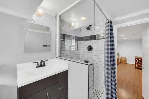 a bathroom with a shower sink and mirror