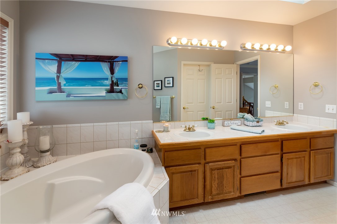 1233 231st Street Southeast Bothell, WA 98021 - Photo 22 of 25 a bathroom with a tub a double vanity sink and a mirror