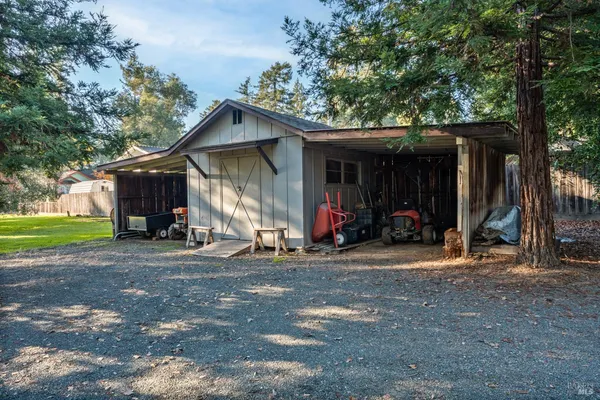 a view of a house with a yard and large tree