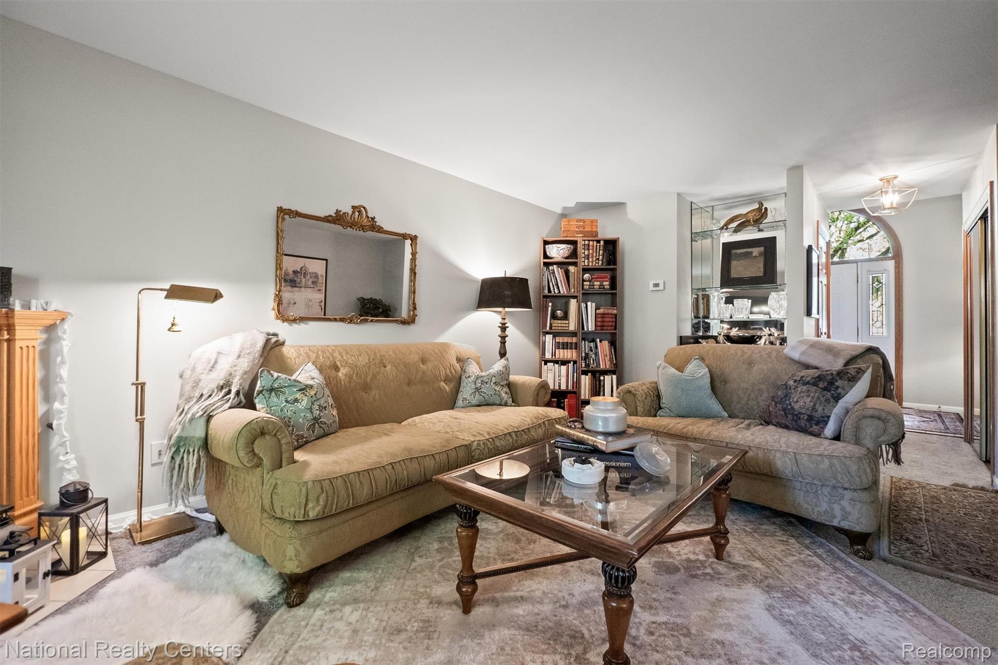 2203 Rochelle Park Drive Rochester, MI 48309 - Photo 10 of 43 Living area featuring light gray walls, plush carpeting, an arched entryway, and a built-in shelving unit