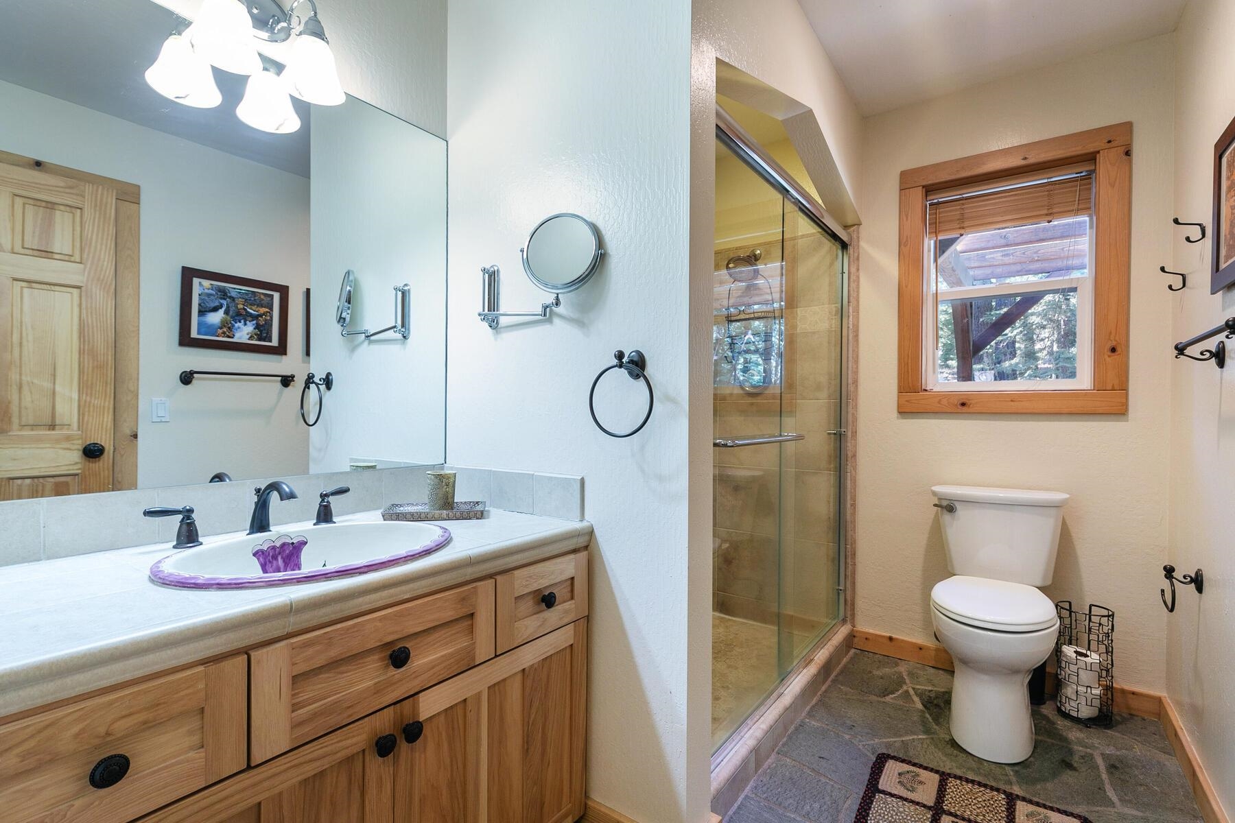 11325 Thelin Drive Truckee, CA 96161 - Photo 13 of 21 a bathroom with a toilet a sink a mirror a vanity and window