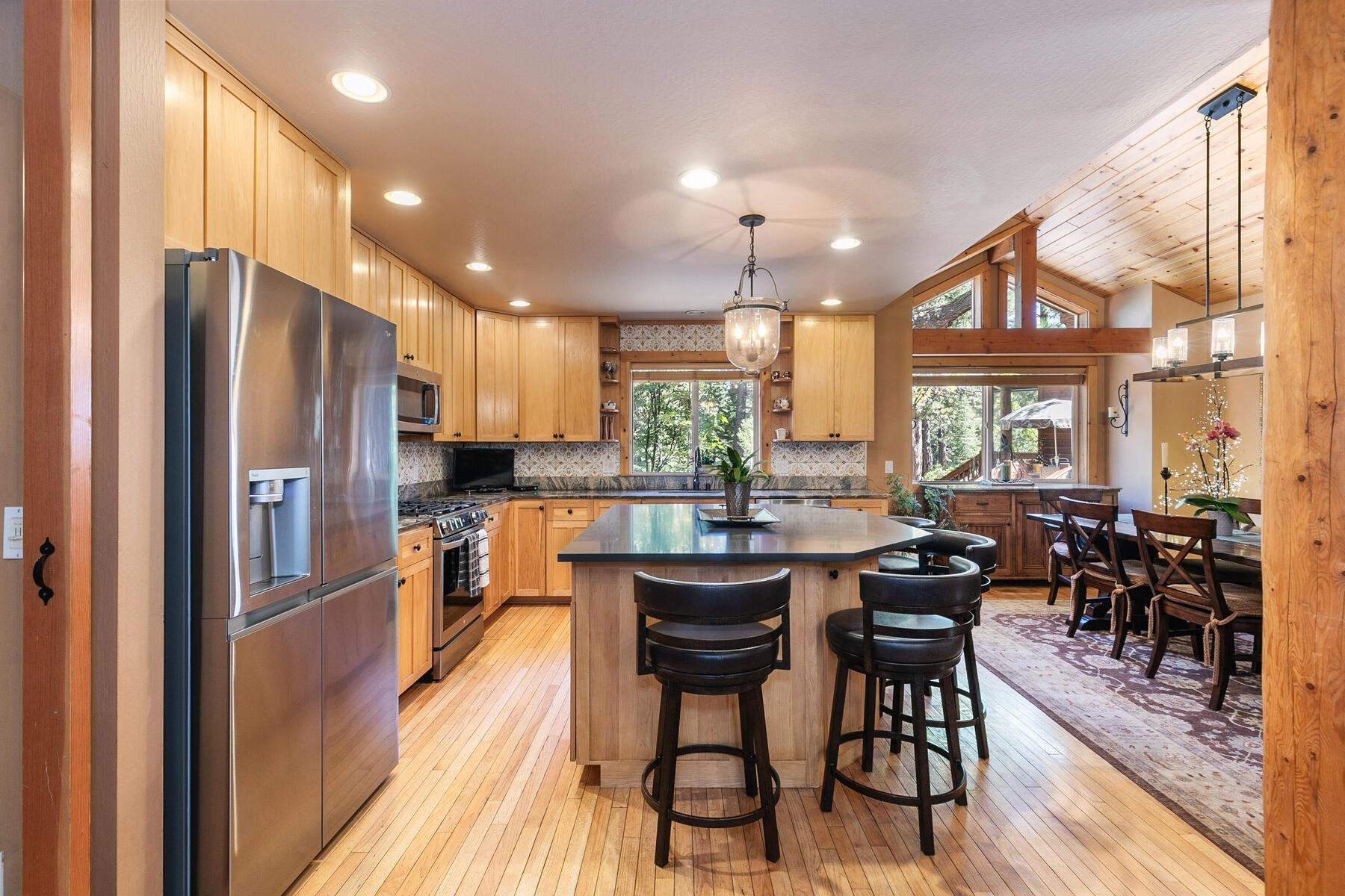 11325 Thelin Drive Truckee, CA 96161 - Photo 9 of 21 a kitchen with stainless steel appliances a dining table chairs stove refrigerator and cabinets