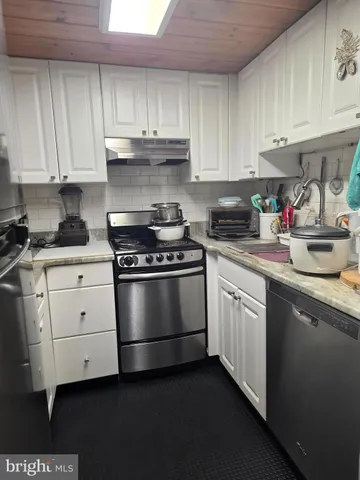 a kitchen with granite countertop white cabinets and appliances