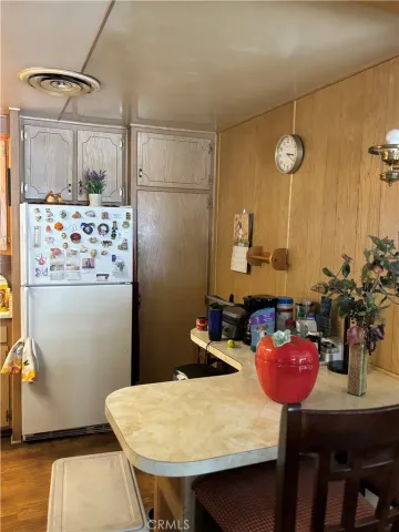 a kitchen with stainless steel appliances kitchen island granite countertop a table chairs and a refrigerator