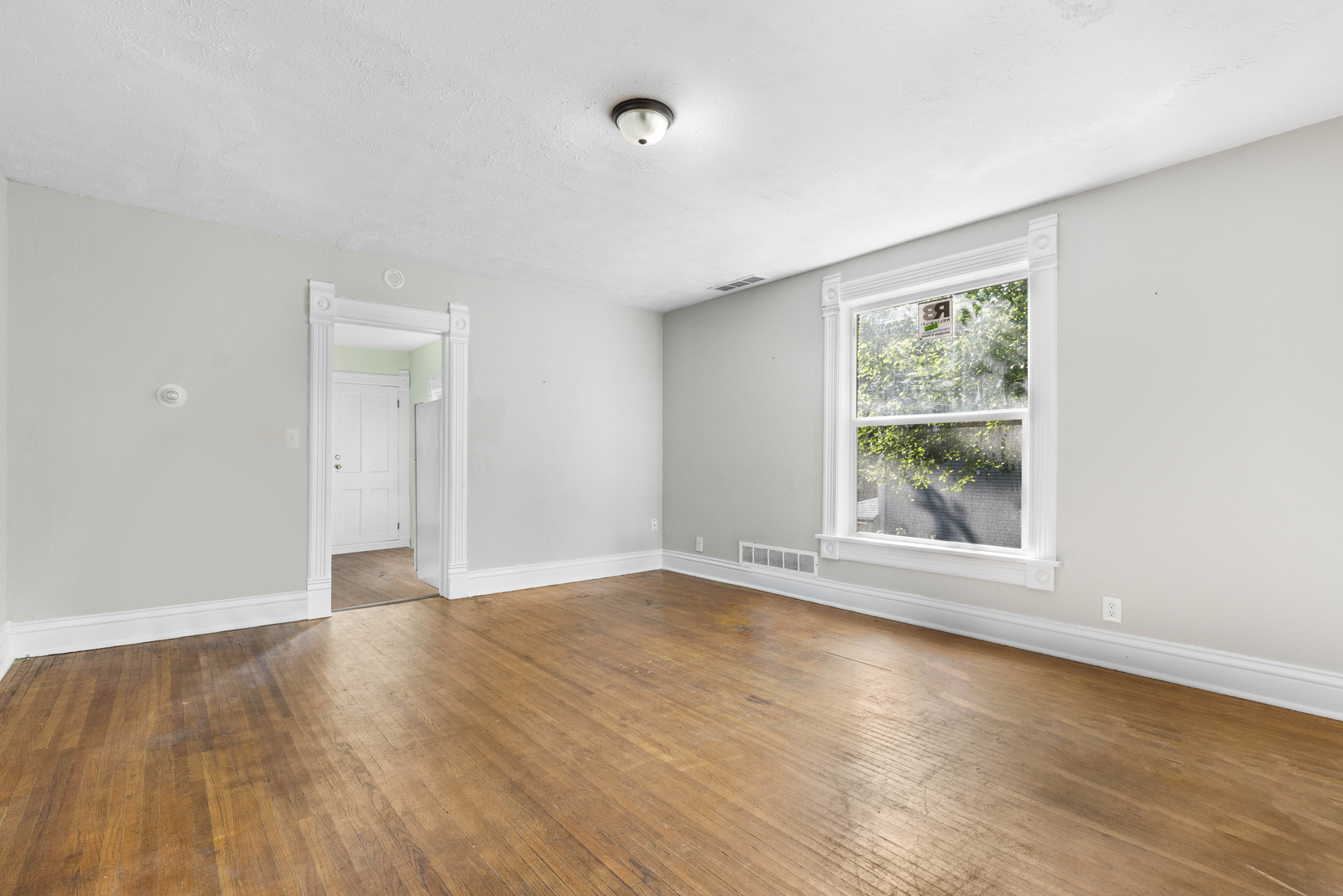 1710 7th Street Rockford, IL 61104 - Photo 2 of 13 a view of an empty room with wooden floor and a window