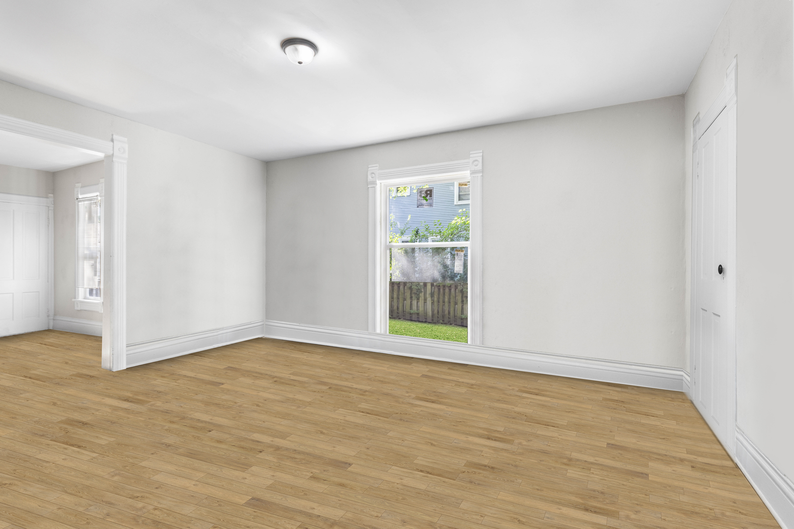 1710 7th Street Rockford, IL 61104 - Photo 8 of 13 a view of an empty room with wooden floor and a window