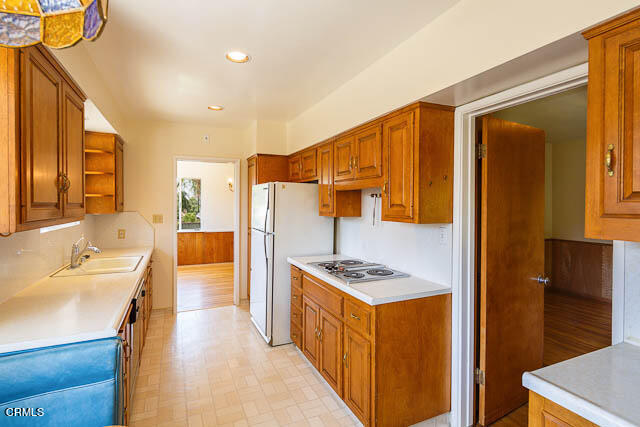 3665 Shadow Grove Road Pasadena, CA 91107 - Photo 13 of 27 a kitchen with stainless steel appliances a refrigerator a sink a stove and wooden cabinets