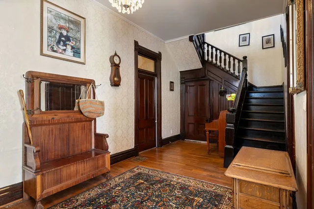 a backyard of a house with table and chairs and a large tree