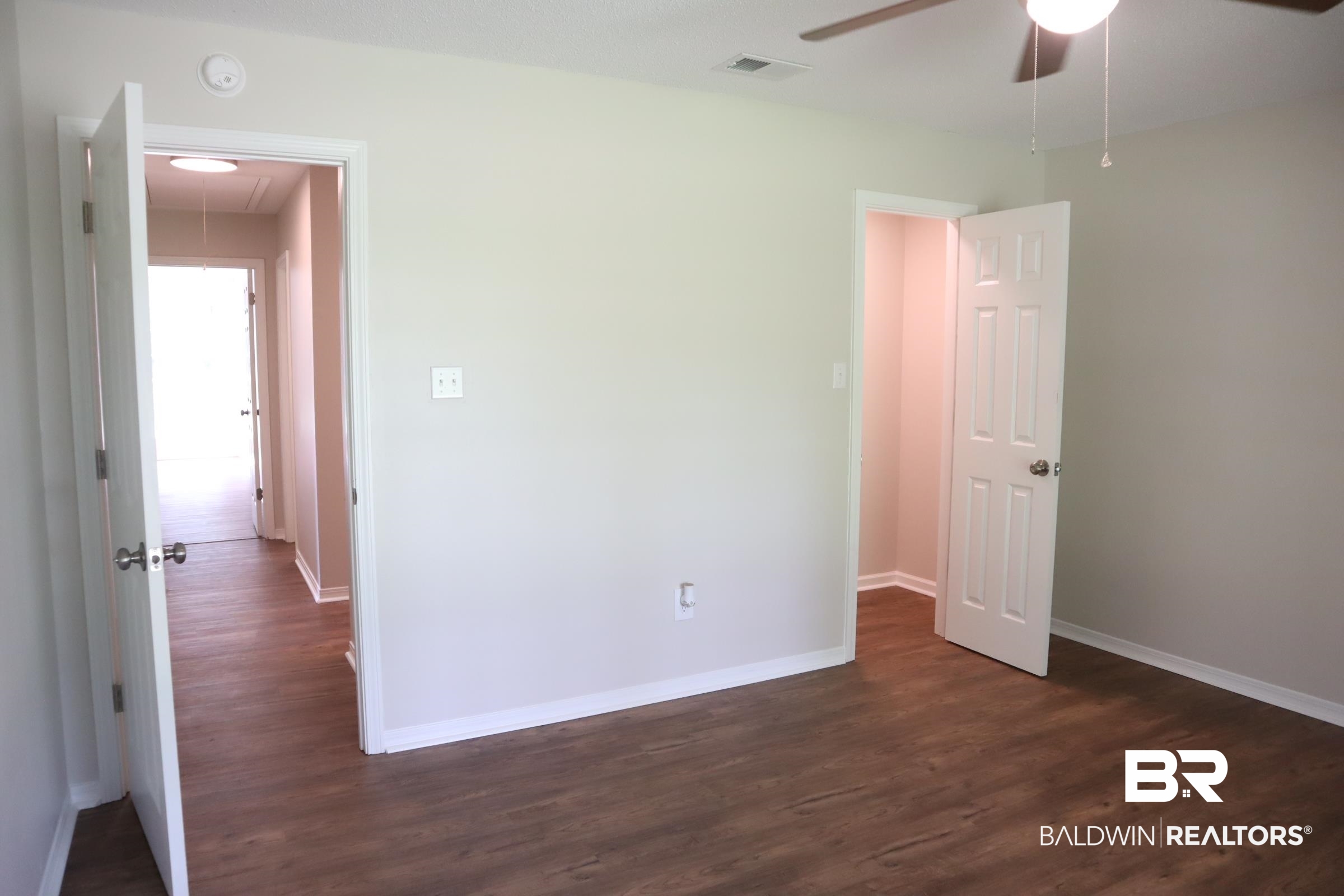 12150 Lee Bishop Road Irvington, AL 36544 - Photo 21 of 26 Spare room featuring attic access, a ceiling fan, baseboards, dark wood-type flooring, and visible vents