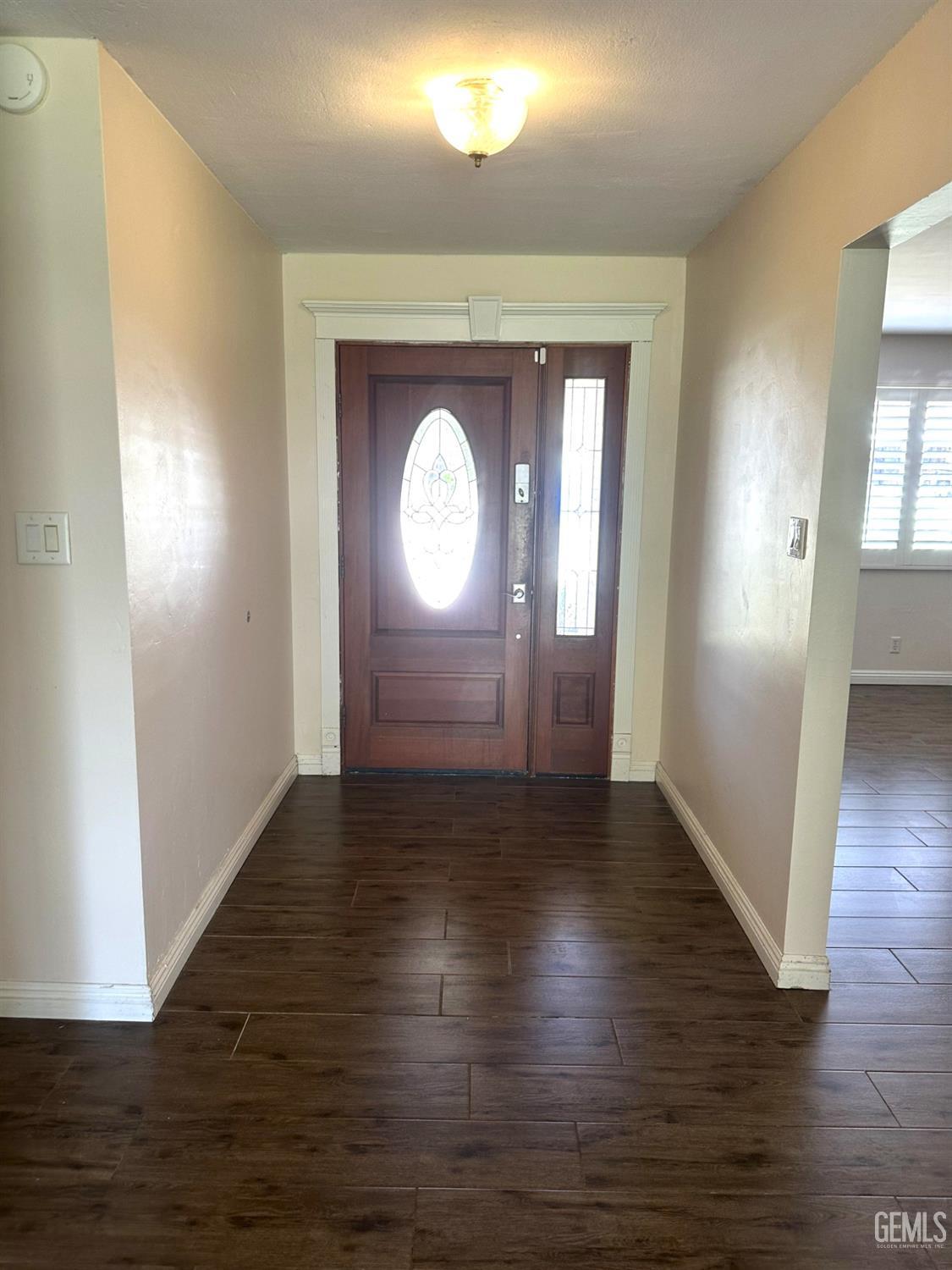 Undisclosed Address Bakersfield, CA 93306 - Photo 3 of 27 an empty room with wooden floor and a mirror