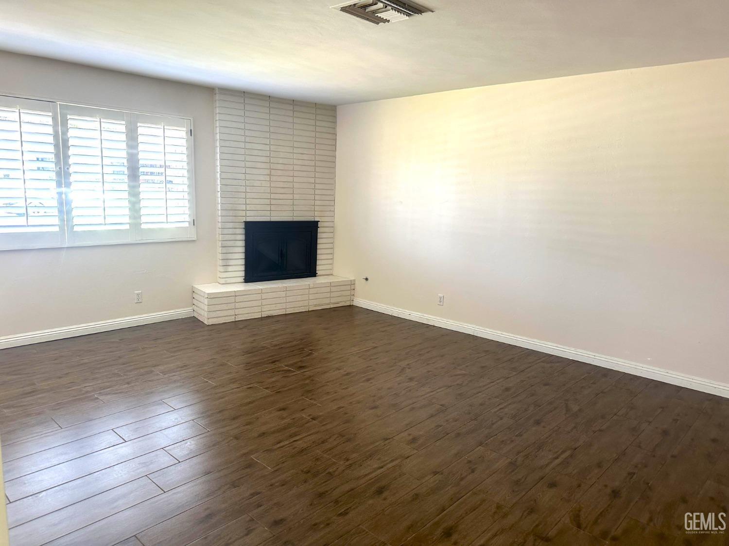 Undisclosed Address Bakersfield, CA 93306 - Photo 6 of 27 an empty room with wooden floor and windows