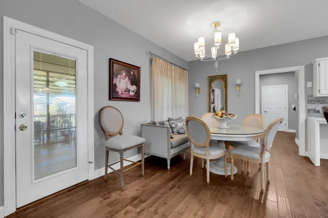 a kitchen with granite countertop white cabinets white stainless steel appliances and wooden floor