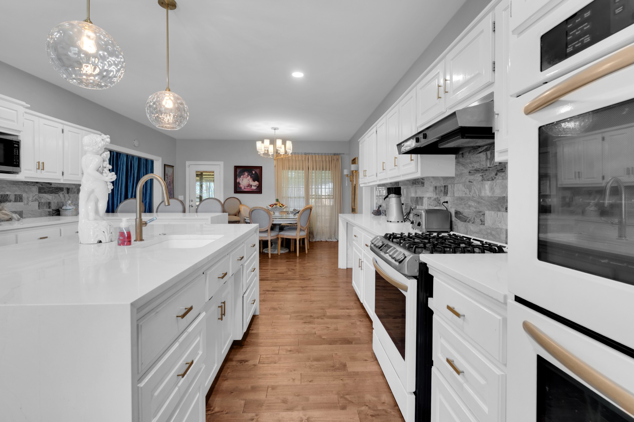 1191 Knights Church Road Decherd, TN 37324 - Photo 17 of 58 a large white kitchen with stainless steel appliances granite countertop a stove oven a sink dishwasher and white cabinets with wooden floor