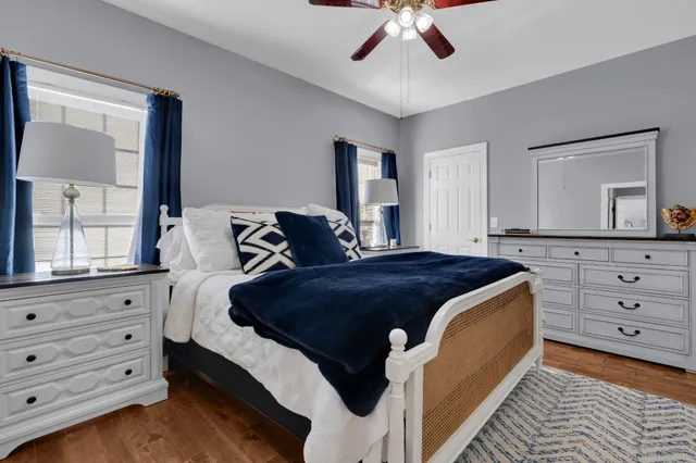 a bathroom with a granite countertop sink a toilet a mirror and shower