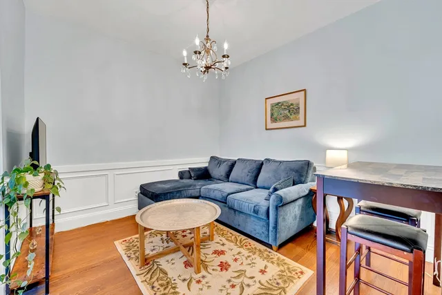 a living room with furniture a chandelier and a rug