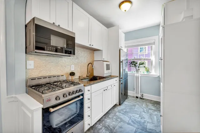 a kitchen with stainless steel appliances a stove a microwave and cabinets