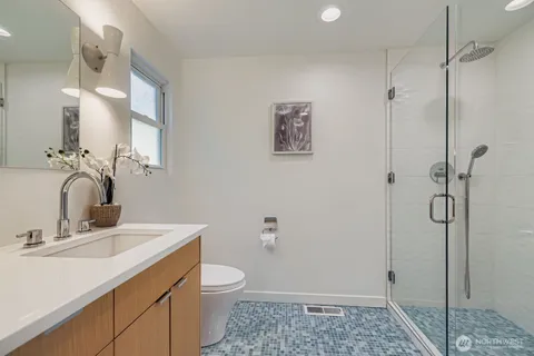 a bathroom with a sink a toilet and shower